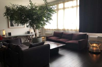 Salle avec des tables et chaises noires disposées en U, projection d’un paon coloré sur un mur blanc, rideaux noirs à droite.