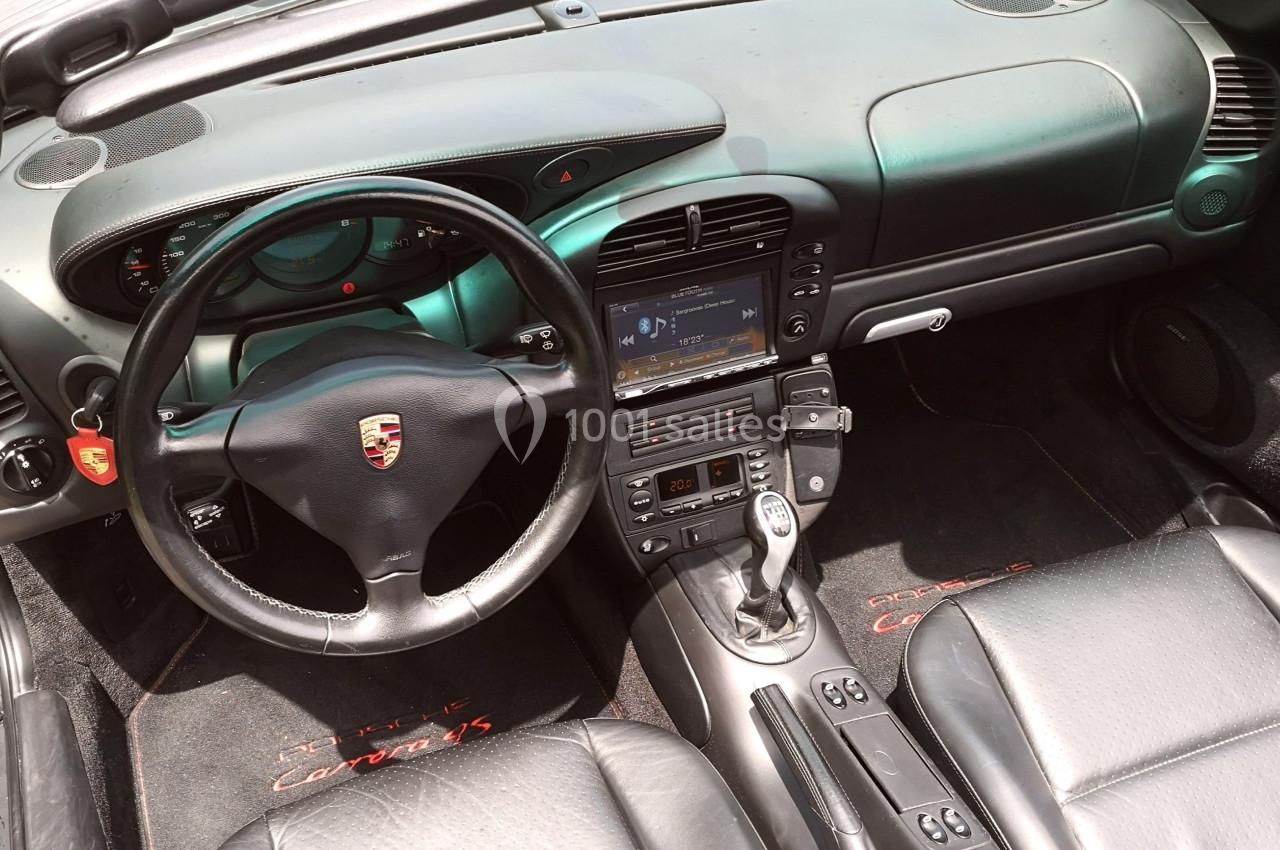 Photo David J. Location #15 Intérieur d'une voiture avec volant, tableau de bord, écran central et sièges en cuir noir.