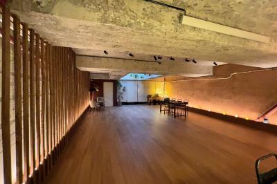 Table en bois dressée avec boissons, fleurs et collations, entourée d'étagères garnies de coussins colorés et décorations.