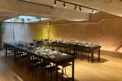 Table en bois dressée avec boissons, fleurs et collations, entourée d'étagères garnies de coussins colorés et décorations.