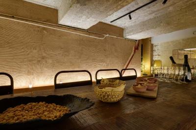 Table en bois dressée avec boissons, fleurs et collations, entourée d'étagères garnies de coussins colorés et décorations.