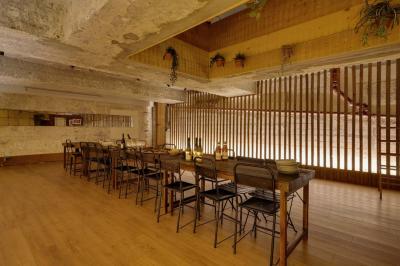 Table en bois dressée avec boissons, fleurs et collations, entourée d'étagères garnies de coussins colorés et décorations.