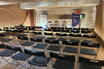 Table en bois dressée avec boissons, fleurs et collations, entourée d'étagères garnies de coussins colorés et décorations.