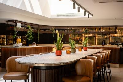 Vue aérienne d'un parking vide entouré de végétation, avec quelques voitures stationnées et un ciel dégagé.