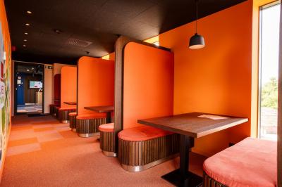 Vue aérienne d'un parking vide entouré de végétation, avec quelques voitures stationnées et un ciel dégagé.