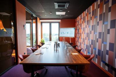 Vue aérienne d'un parking vide entouré de végétation, avec quelques voitures stationnées et un ciel dégagé.