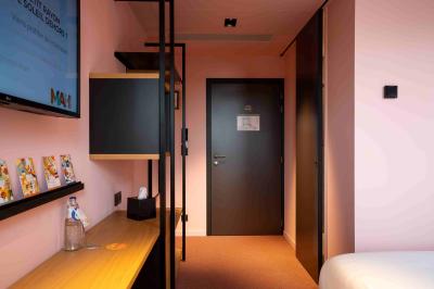 Vue aérienne d'un parking vide entouré de végétation, avec quelques voitures stationnées et un ciel dégagé.