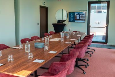 Vue aérienne d'un parking vide entouré de végétation, avec quelques voitures stationnées et un ciel dégagé.