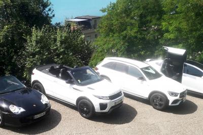 Six voitures blanches et noires alignées sur un parking, disponibles pour des locations de courte durée.