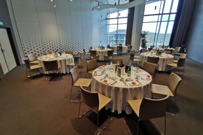 Miniature Location salle Chouilly (Marne) - Champagne Nicolas Feuillatte #5 Salle de réception avec tables rondes dressées pour un repas, entourées de chaises, près de grandes baies vitrées.