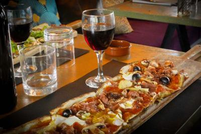 Cour intérieure éclairée de nuit, avec des chaises et tables sous un arbre aux feuilles jaunies en automne.