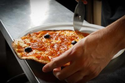 Cour intérieure éclairée de nuit, avec des chaises et tables sous un arbre aux feuilles jaunies en automne.