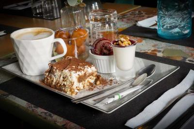 Cour intérieure éclairée de nuit, avec des chaises et tables sous un arbre aux feuilles jaunies en automne.