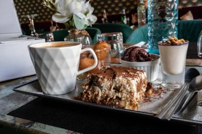 Cour intérieure éclairée de nuit, avec des chaises et tables sous un arbre aux feuilles jaunies en automne.
