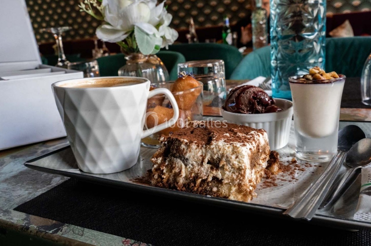 Assiette avec un cappuccino, un tiramisu, une glace au chocolat et une verrine garnie de noix, sur une table de café.