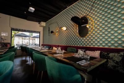 Cour intérieure éclairée de nuit, avec des chaises et tables sous un arbre aux feuilles jaunies en automne.