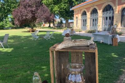 Table ronde élégamment dressée avec des assiettes blanches, des couverts dorés et un bouquet de roses, près d'une baie…