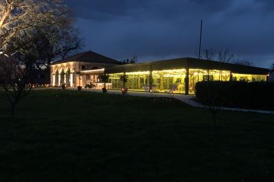 Table ronde élégamment dressée avec des assiettes blanches, des couverts dorés et un bouquet de roses, près d'une baie…