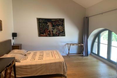 Table ronde élégamment dressée avec des assiettes blanches, des couverts dorés et un bouquet de roses, près d'une baie…