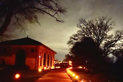 Table ronde élégamment dressée avec des assiettes blanches, des couverts dorés et un bouquet de roses, près d'une baie…