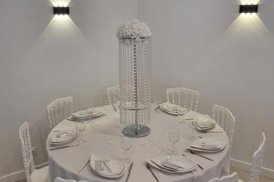 Toilettes modernes avec cuvette suspendue, carrelage gris, mosaïque dorée et accessoires noirs.