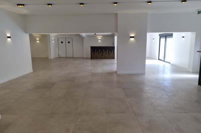 Toilettes modernes avec cuvette suspendue, carrelage gris, mosaïque dorée et accessoires noirs.