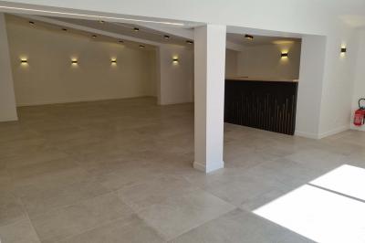 Toilettes modernes avec cuvette suspendue, carrelage gris, mosaïque dorée et accessoires noirs.