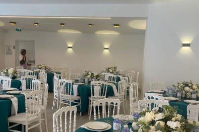 Toilettes modernes avec cuvette suspendue, carrelage gris, mosaïque dorée et accessoires noirs.