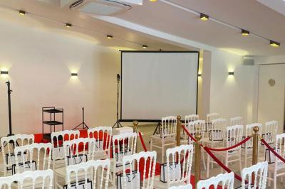 Toilettes modernes avec cuvette suspendue, carrelage gris, mosaïque dorée et accessoires noirs.