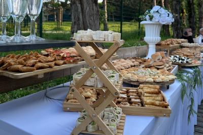 Salle de réception moderne avec tables dressées, sol en carrelage gris, éclairage suspendu et décor floral.