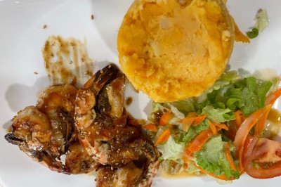 Assiette contenant un steak grillé, une purée de pommes de terre, une salade verte et une sauce servie dans un ramequin.