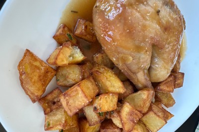 Assiette contenant un steak grillé, une purée de pommes de terre, une salade verte et une sauce servie dans un ramequin.