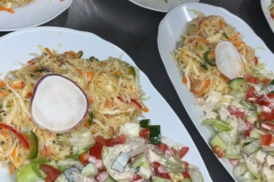 Assiette contenant un steak grillé, une purée de pommes de terre, une salade verte et une sauce servie dans un ramequin.