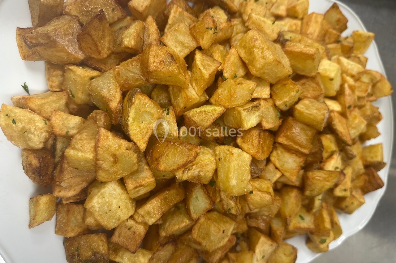 Pommes de terre rissolées dorées servies sur un plat blanc.