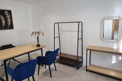 Toilettes modernes avec cuvette suspendue, carrelage gris, mosaïque dorée et accessoires noirs.