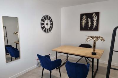 Toilettes modernes avec cuvette suspendue, carrelage gris, mosaïque dorée et accessoires noirs.