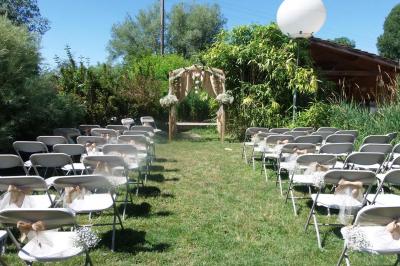 Chambre lumineuse avec lits en bois, bureau, armoire, décorations végétales et vue sur un jardin par la fenêtre.