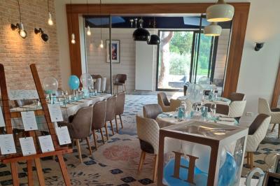 Paysage de golf avec pelouses verdoyantes, reliefs ondulés et maisons en arrière-plan sous un ciel dégagé.