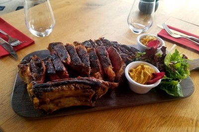 Plateau d'éclairs salés disposés sur une table avec des bouteilles de champagne dans un seau de glace en arrière-plan.