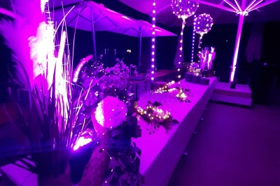 Plateau d'éclairs salés disposés sur une table avec des bouteilles de champagne dans un seau de glace en arrière-plan.