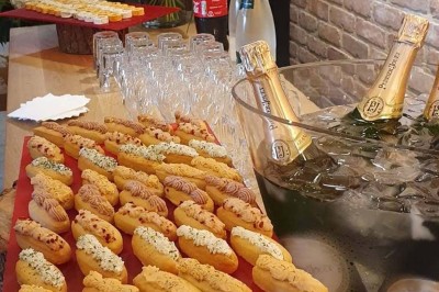 Plateau d'éclairs salés disposés sur une table avec des bouteilles de champagne dans un seau de glace en arrière-plan.