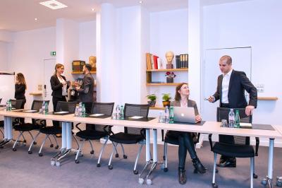 Vue d'un terrain de golf verdoyant avec des arbres et une ville en arrière-plan sous un ciel dégagé.