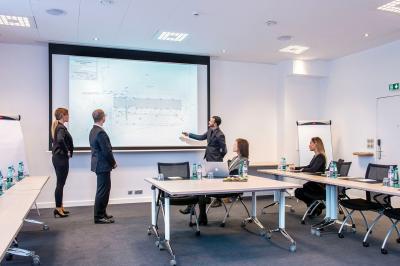 Vue d'un terrain de golf verdoyant avec des arbres et une ville en arrière-plan sous un ciel dégagé.