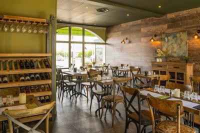 Un groupe de cinq personnes souriantes trinque avec des verres de vin dans un intérieur chaleureux et décoré.