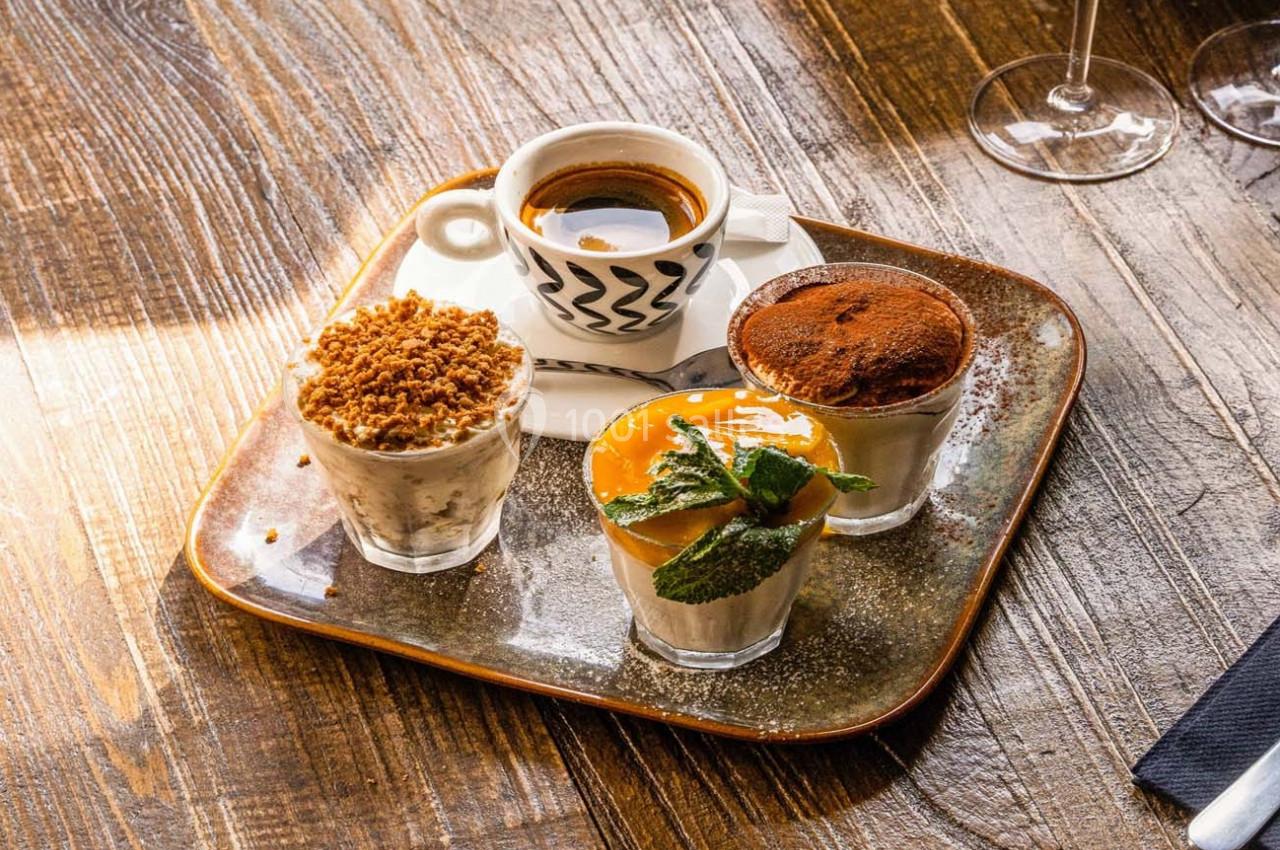 Plateau avec un café expresso et trois desserts variés, dont un crumble, une mousse au chocolat et un dessert fruité.