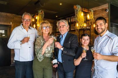 Assiette de pâtes rigatoni à la truffe avec une tuile de fromage, servie sur une table en bois.