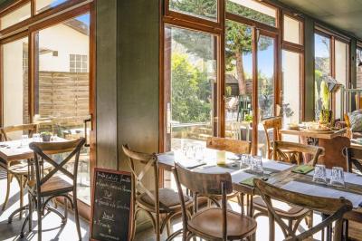 Assiette de pâtes rigatoni à la truffe avec une tuile de fromage, servie sur une table en bois.