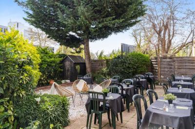 Assiette de pâtes rigatoni à la truffe avec une tuile de fromage, servie sur une table en bois.