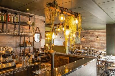 Assiette de pâtes rigatoni à la truffe avec une tuile de fromage, servie sur une table en bois.