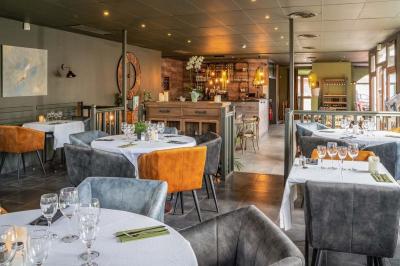 Assiette de pâtes rigatoni à la truffe avec une tuile de fromage, servie sur une table en bois.